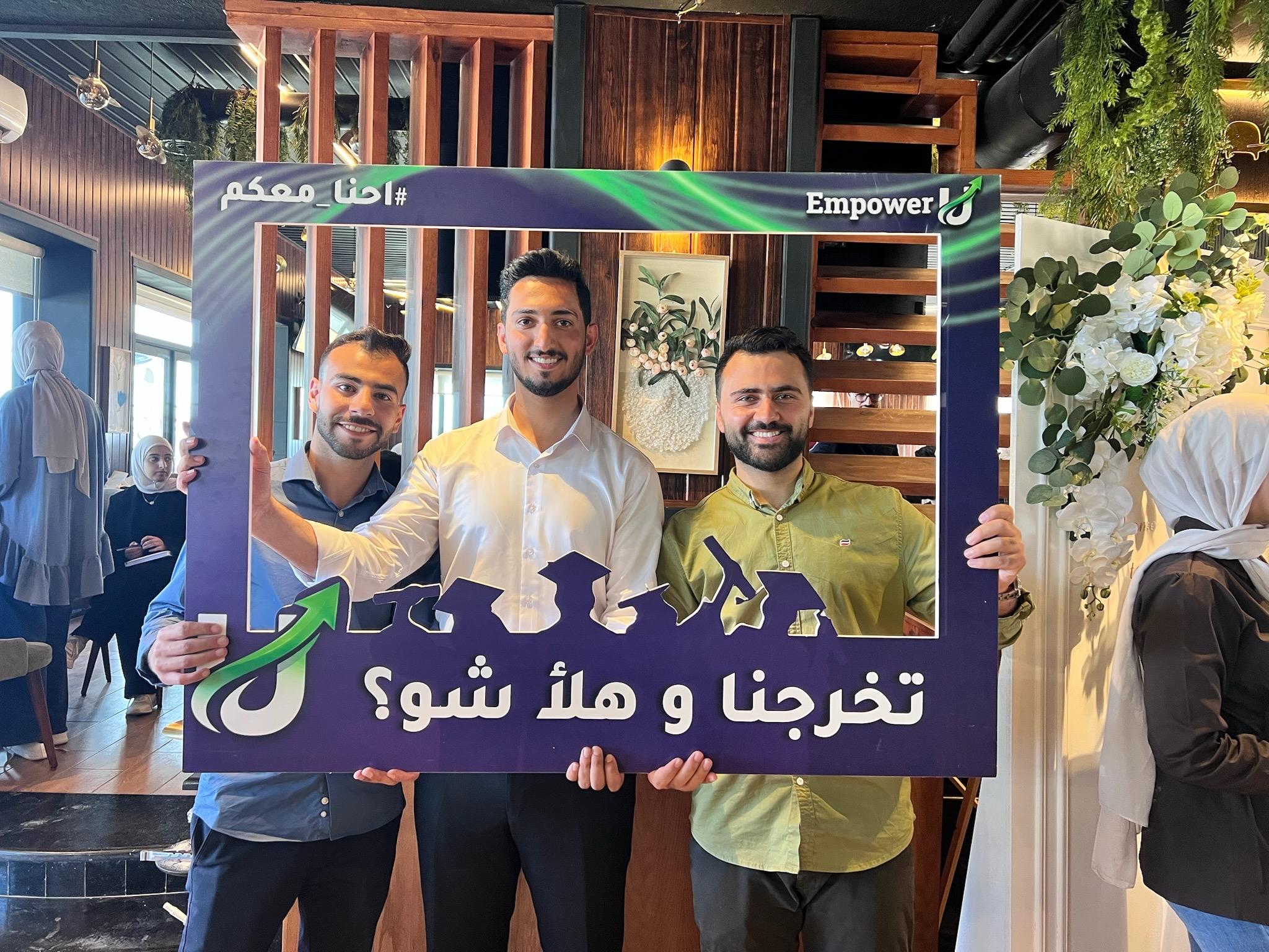 Three Wave One participants celebrating with an EmpowerU graduation frame
